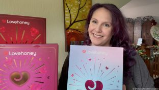 product tester holding the 2026 lovehoney enjoy calendar alongside the couples and romance calendar