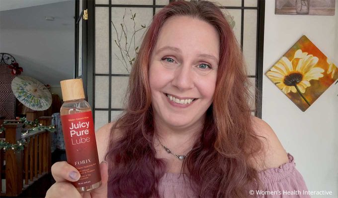 product tester alison holding juicy pure lube bottle in her hand and smiling