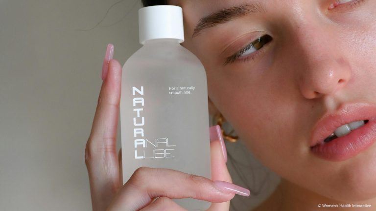 woman holding a bottle with a label that reads natural anal lube