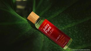 bottle of juicy pure water-based lube resting in the crevice of a giant leaf as the best anal lube