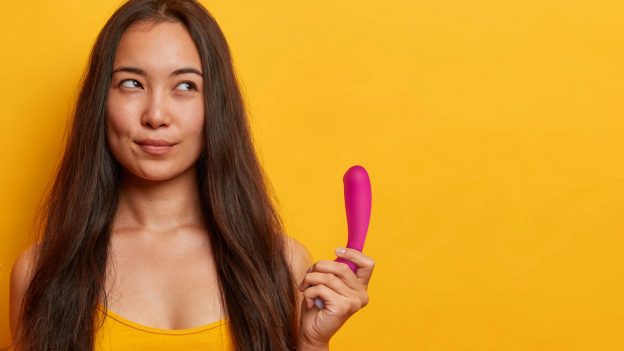 Photograph Of Mischievous Woman Holding A G-Spot Vibrator