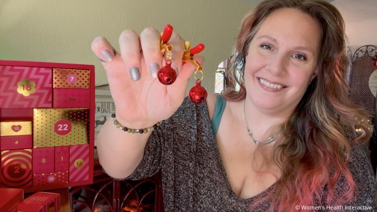 sex toy tester alison holding jingle bell nipple clamps next to a sexy advent calendar
