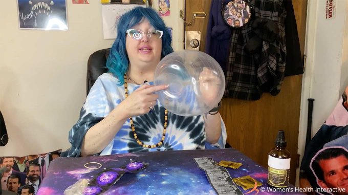 wednesday pointing to the orifice of the blown up condom fleshlight she made