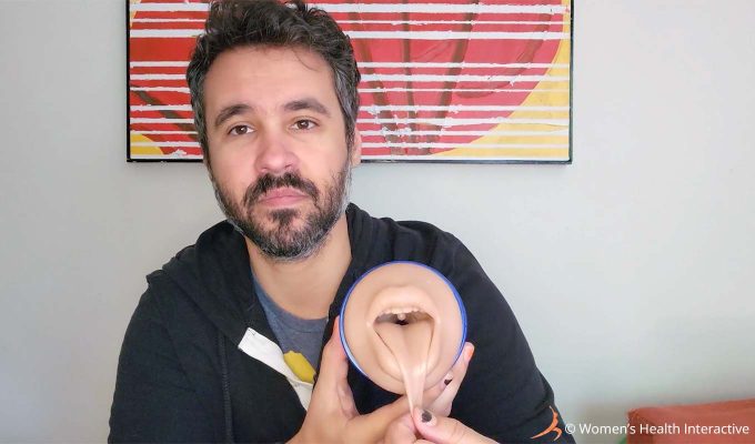 photograph of product tester justin holding the boost blow mouth fleshlight with the mouth facing the viewer as he pulls the tongue down to show the inner mouth detailing