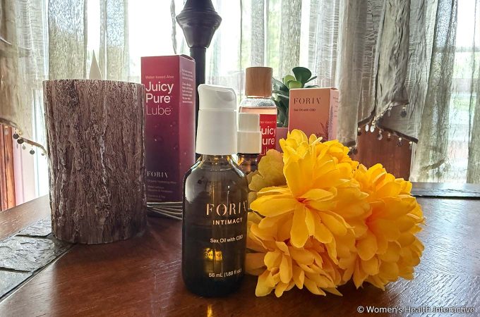 an array of foria sexual wellness products with flowers and candles