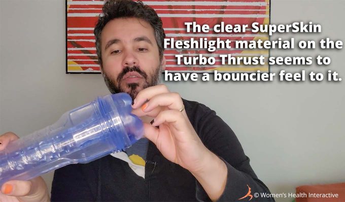 photograph of product tester justin feeling the icy blue superskin material of the clear transparent fleshlight turbo thrust with text overlay that reads: the clear superskin fleshlight material of the turbo thrust seems to have a bouncier feel to it