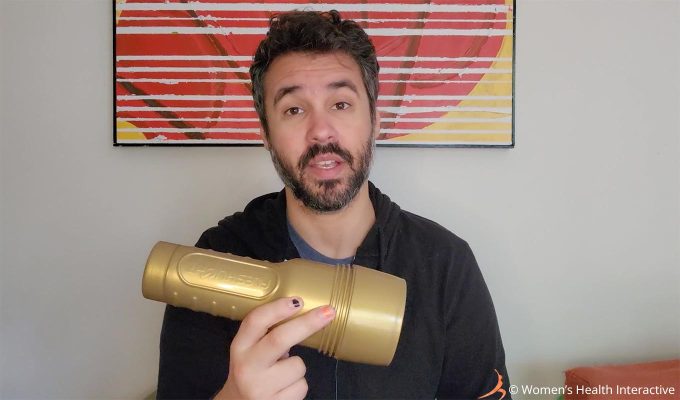 photograph of product tester justin holding a gold-cased fleshlight stamina training unit pocket pussy and stroker in his hand as part of the testing and review process