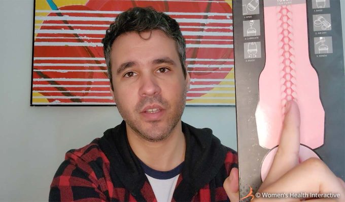 photograph of product tester justin holding his finger against the texture map on the back of the fleshlight vibro lady box to demonstrate the sleeve's tightness