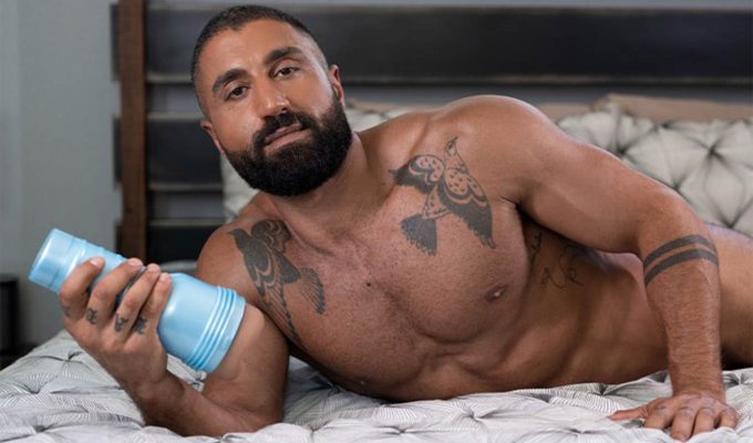 photography of fleshjack boys sharok laying on a bed holding the fleshjack modeled after him