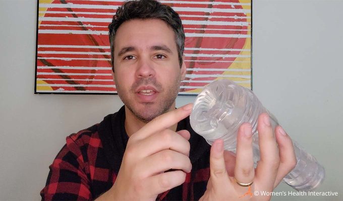 photograph of product tester justin holding the clear fleshlight go torque in his hand while pointing to the ice-like orifice