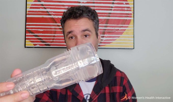 photograph of product tester justin holding the clear fleshlight go torque ice stroker in his hand with the cap applied to the end