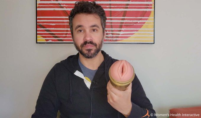 photograph of product tester justin holding the fleshlight stamina training stu lady in his hand with the vulva orifice facing the viewer to display the superskin material the sleeve is made from