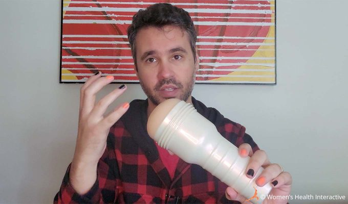 photograph of product tester justin holding the violet myers anal fleshlight with ahegao texture while making a gesture with his hand to demonstrate its tight grip