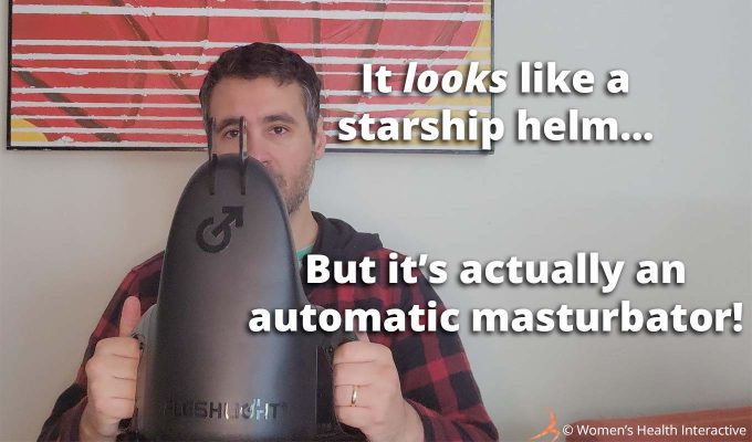 photograph of product tester justin playfully holding the fleshlight universal launch in both hands with text overlay that reads: it looks like a starship helm but it's actually an automatic masturbator