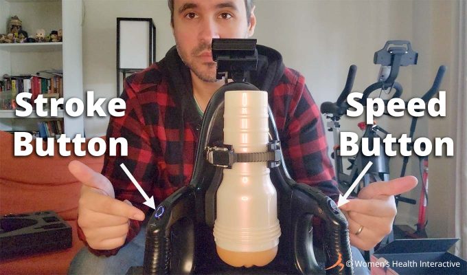photograph of product tester justin pointing to the stroke and speed buttons on the fleshlight universal launch masturbator with text overlay and arrows to show the stroke button on the left and the speed button on the right