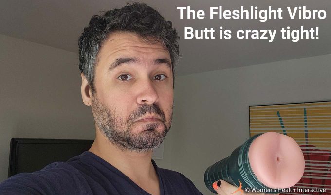 photograph of product tester justin holding the fleshlight vibro butt with the anal orifice facing the viewer while frowning with an unsure expression with text overlay that reads: the fleshlight vibro butt is crazy tight