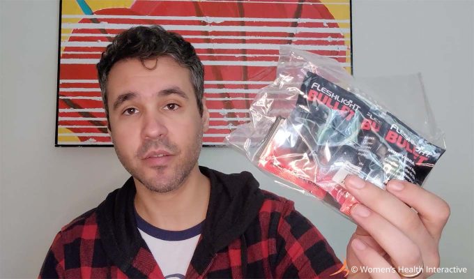 photograph of an unimpressed product tester justin holding the packet of three bullet vibrators and replacement batteries that came with the fleshlight vibro lady vibrating pocket pussy