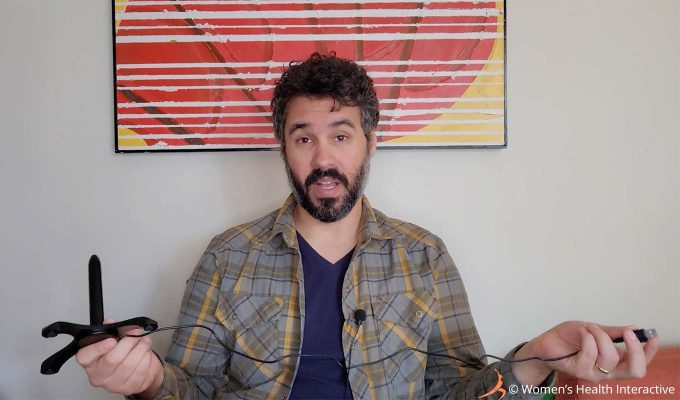 photograph of product tester justin holding the fulll length of the usb cord on the fleshlight sleeve warmer to demonstrate its short length, the only thing he didn't love about the product while testing and reviewing it