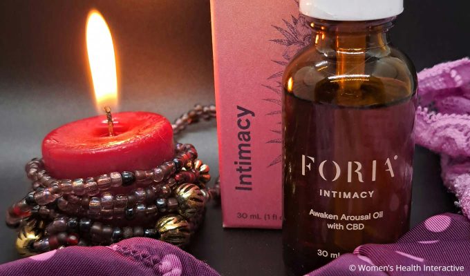 foria awaken arousal oil with cbd next to candle and lingerie