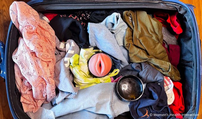 aerial photograph of a fleshlight among clothing packed in an open suitcase