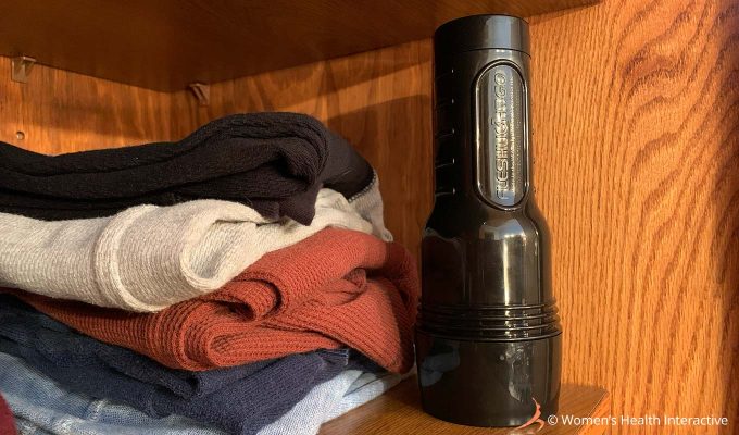 photograph of a fleshlight pocket pussy standing upright on a closet shelf next to a stack of folded clothing as an example of a good place to hide a fleshlight while not in use