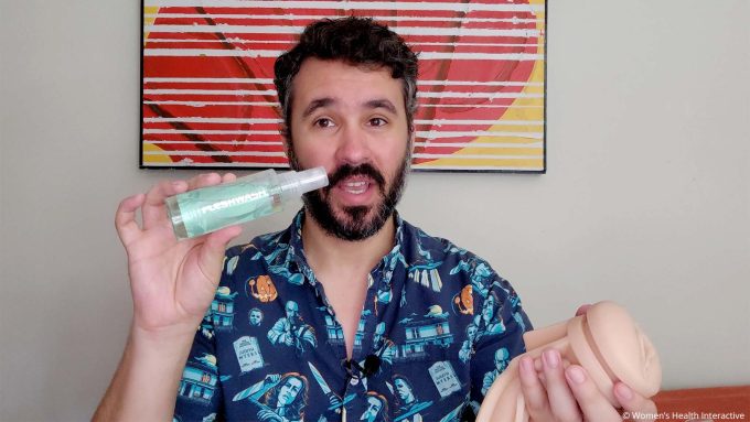 photograph of justin holding a fleshlight sleeve and a bottle of fleshwash cleaner in his hand