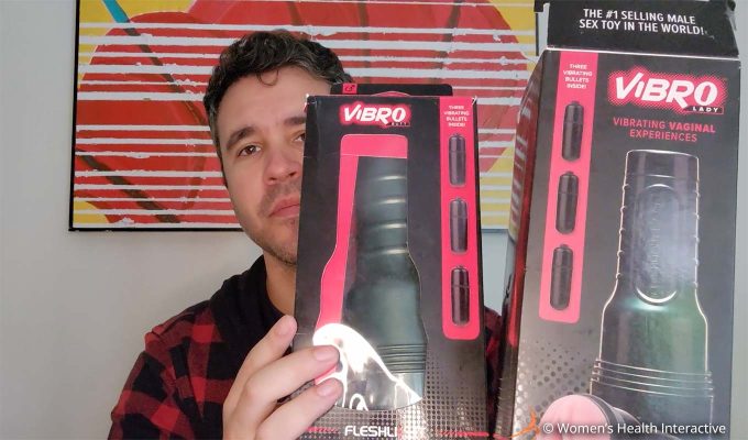 photograph of product tester justin holding the boxes for the fleshlight vibro lady and fleshlight vibro butt in his hands while peeking out from behind them