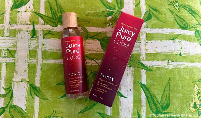 a box and a bottle of foria juicy pure laying on a green fabric background