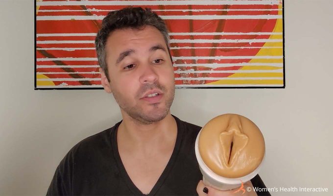 photograph of justin holding the autumn falls fleshlight while looking at the orifice with a quizzical expression