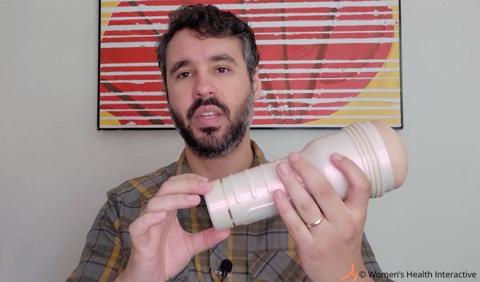 photograph of product tester justin unscrewing the bottom cap of the riley reid utopia pocket pussy, which can adjust suction during use and be removed completely during cleaning