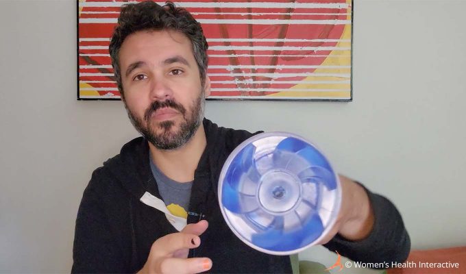 photograph of product tester justin holding the clear and transparent ice fleshlight turbo thrust in his hand with the orifice facing the viewer to show its mechanical fan-like design