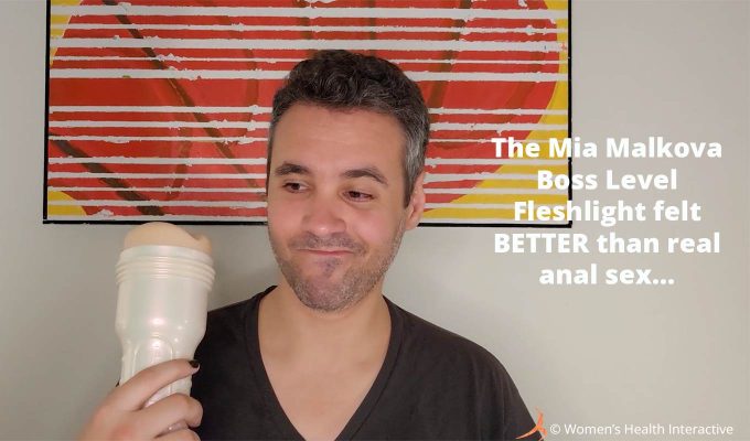 photograph of tester justin holding the mia malkova boss level fleshlight while looking at it with a cheeky expression, text overlay reads: the mia malkova boss level fleshlight felt better than real anal sex