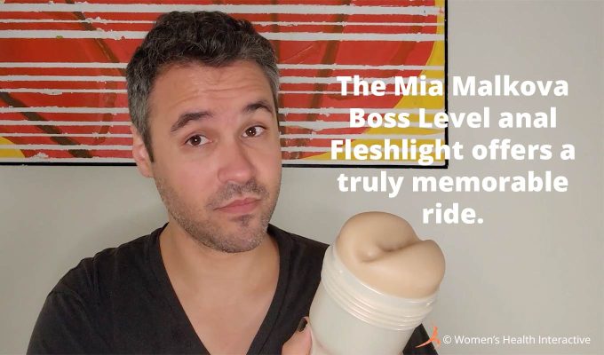 photograph of tester justin holding the mia malkova boss level anal fleshlight while looking at the viewer with text overlay that reads: the mia malkova boss level anal fleshlight offers a truly memorable ride