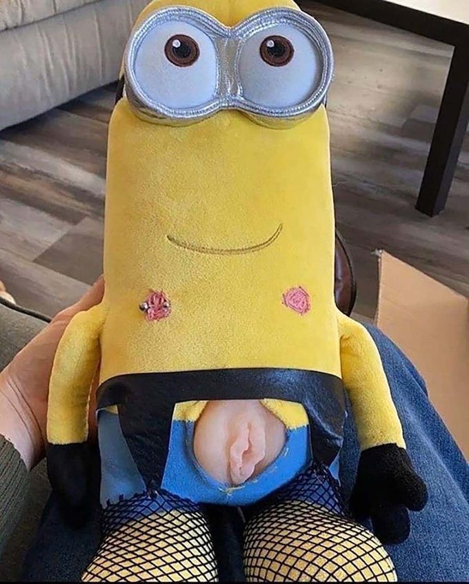 photograph of a plushie minion with a hole cut out at the groin, featuring the vulva of a fleshlight someone inserted inside of it