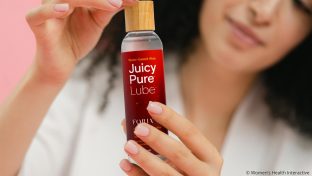woman holding a bottle of juicy pure water-based lube in her hands as the best natural and organic personal lubricant
