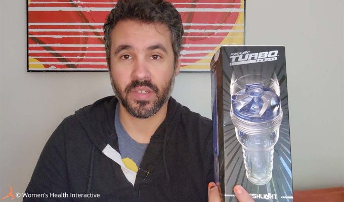 photograph of product tester justin holding the fleshlight turbo thrust clear and transparent masturbator in his hands while reviewing it