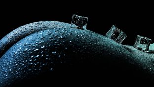 Close Up Photograph Of Hill-Like Buttocks Shimmering With Water Droplets And Small Ice Cubes