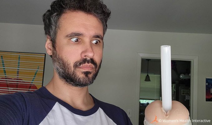 photograph of product tester justin with an amusingly surprised expression on his face as he stares at the hard plastic shipping tube sticking out of the riley reid fleshlight after unboxing it