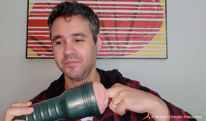 photograph of product tester justin wearing a smirk on his face while inserting one finger into the fleshlight vibro lady vibrating pocket pussy and stroker during the testing process