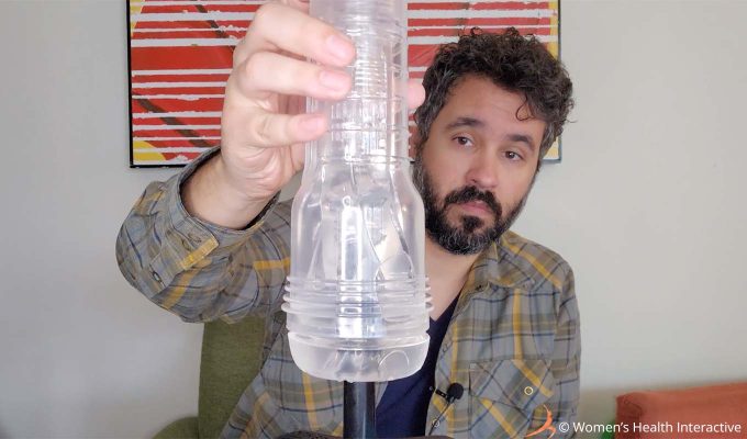 photograph of product tester justin sliding a clear fleshlight onto the fleshlight sleeve warming stick as part of a demonstration on how to use it
