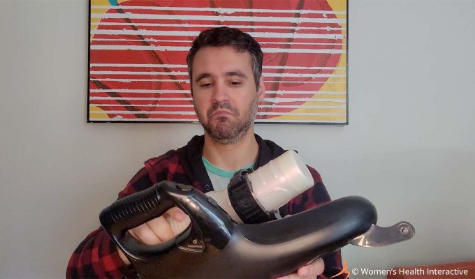 photograph of product tester justin attaching and adjusting a pornstar girl full sized fleshlight into the launch automatic masturbator and looking at the unit as though considering the pros and cons associated with using it