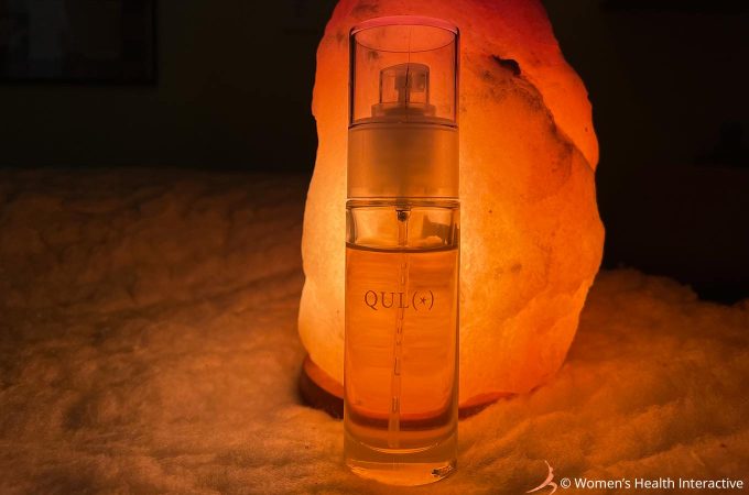 photograph of toca's qulo cbd anal lube lit from behind with a salt lamp to display its logo, which features an asterisk between two crescents to mimic an anus