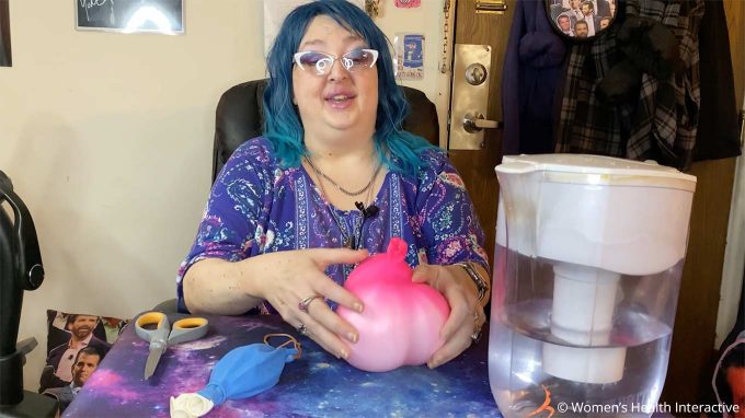 photograph of wednesday adjusting the water-filled balloons in her diy fleshlight