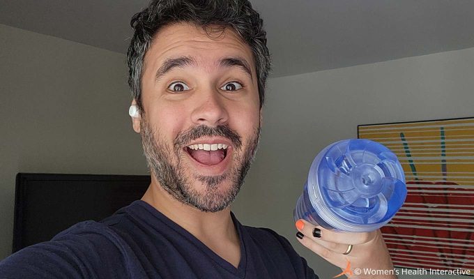 photograph of product tester justin holding the clear and transparent fleshlight turbo thrust ice in his hand with a wide excited smile on his face