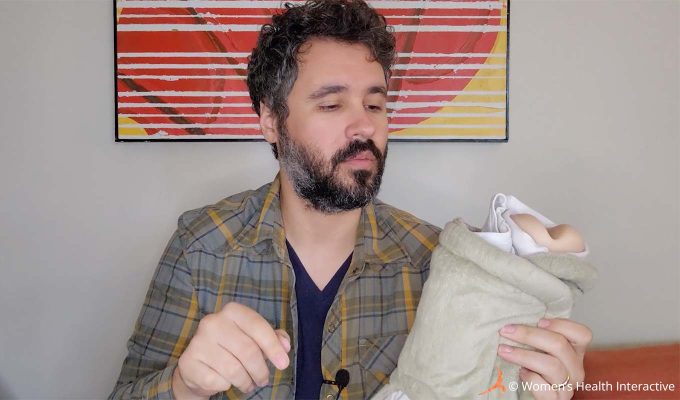 photograph of product tester justin holding a fleshlight pocket pussy sleeve inside of an electric heating pad as part of a demonstration on how to warm a fleshlight with it