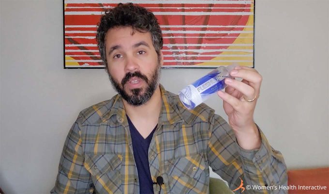 photograph of product tester justin holding a bottle of fleshlube fleshlight lubricant in his hand while talking about using warmed personal lubricant to warm a fleshlight pocket pussy sleeve