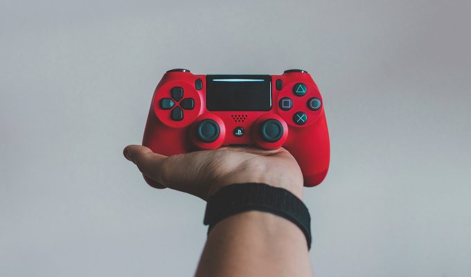 Photograph Of Single Hand Holding A Red Video Game Controller