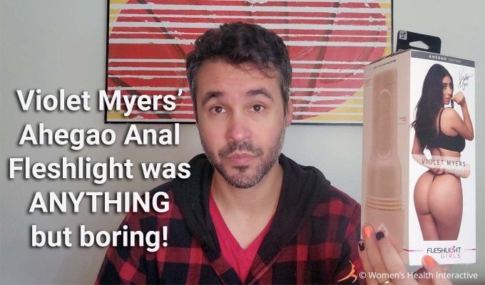 photograph of product tester justin holding the violet myers anal fleshlight ahegao box with text overlay that reads: violet myers' ahegao anal fleshlight was anything but boring