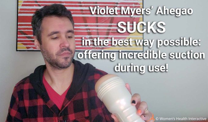 photograph of product tester justin holding the violet myers anal fleshlight in his hand while looking at it closely with text overlay that reads: violet myers' ahegao sucks in the best way possible, offering incredible suction during use