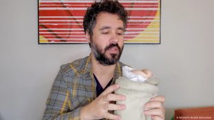 photograph of product tester justin holding a fleshlight pocket pussy wrapped up in an electric heating pad as part of a demonstrating on the best, easiest, and safest ways to warm a fleshlight